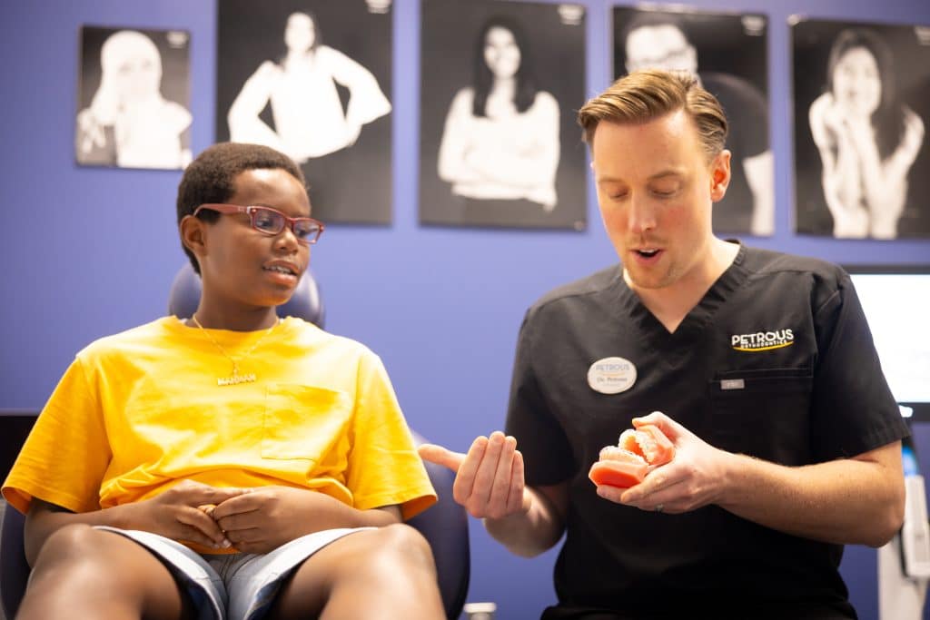 Orthodontist Showing Typodonts to Teen Patient at Petrous Orthodontics in Royal Oak, MI